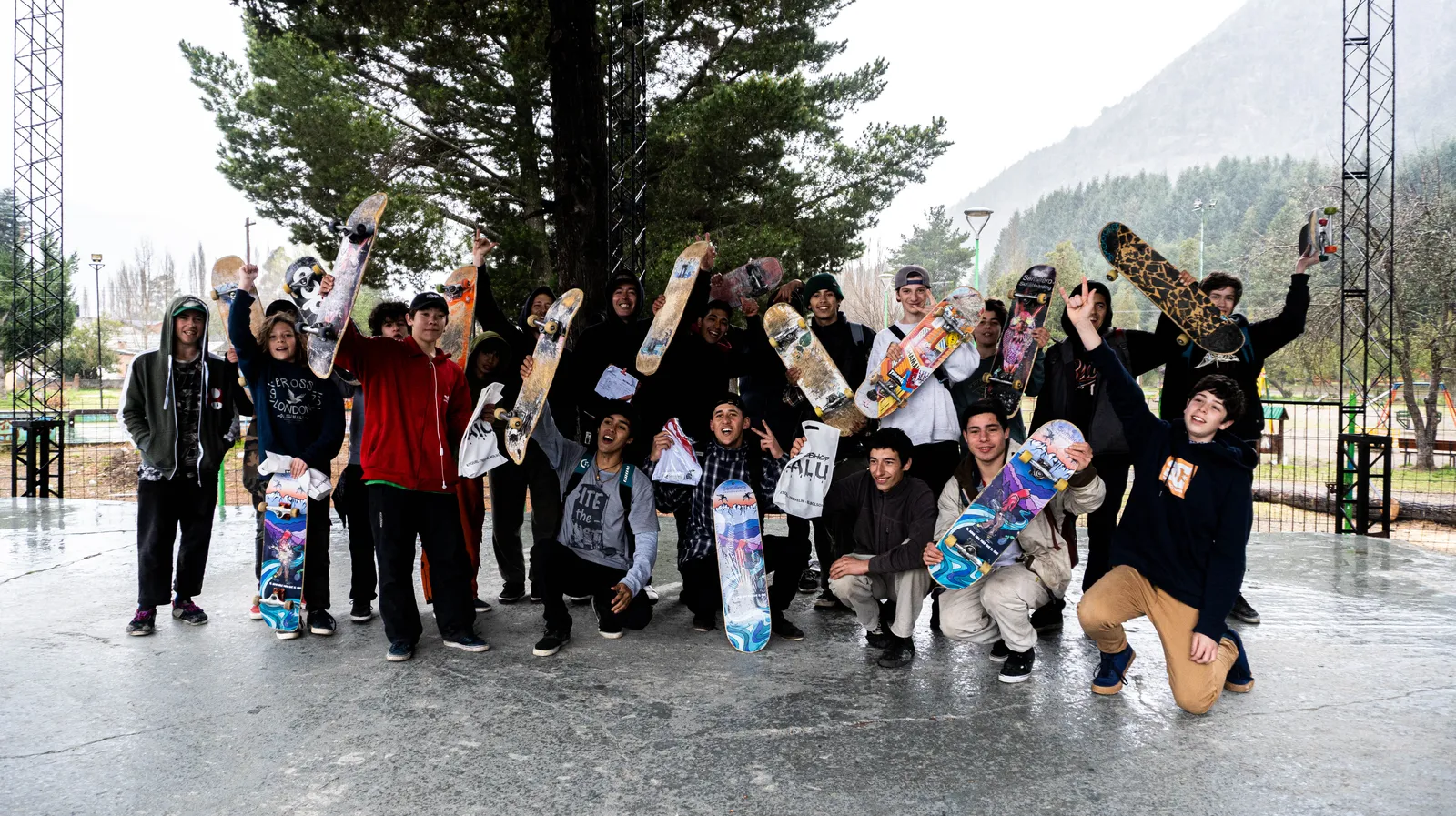 Grupo de skaters con sus tablas en alto en un skatepark con nieve