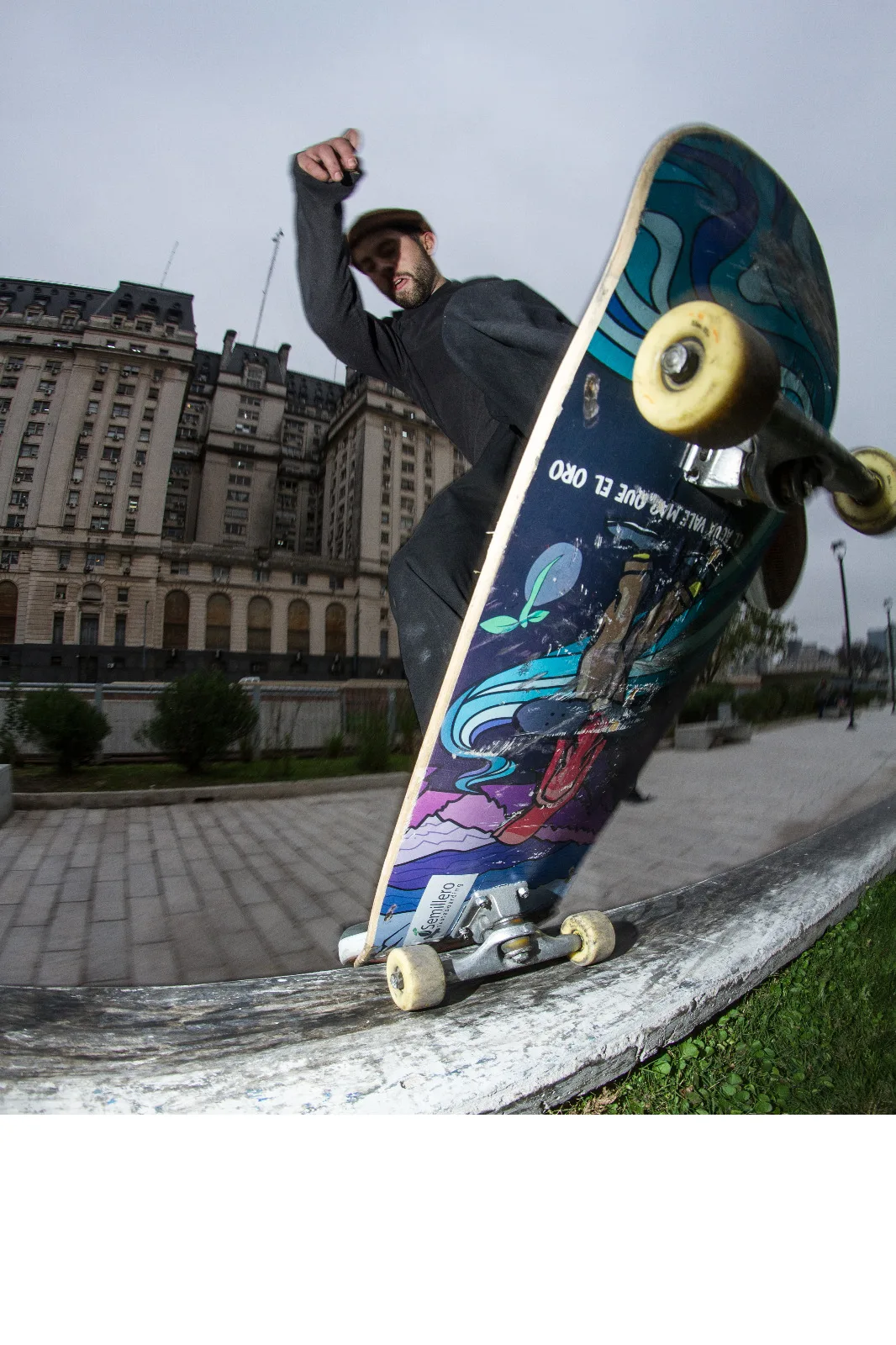 Skater con la tabla 'El agua vale más que el oro' en la calle